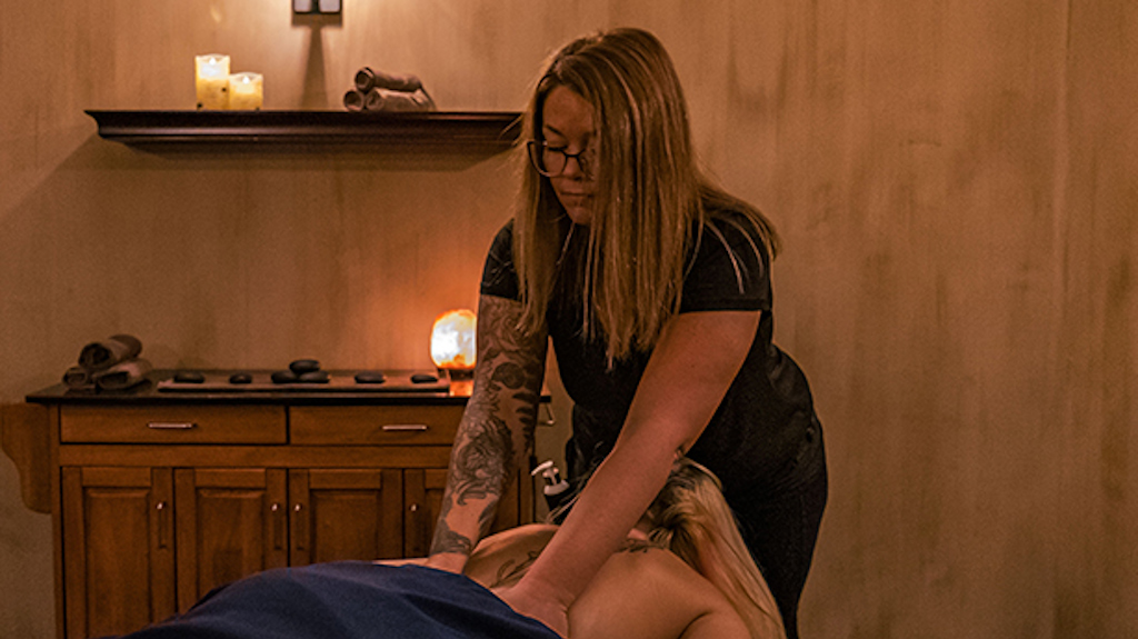 A massage therapist gives a woman a deep tissue massage.